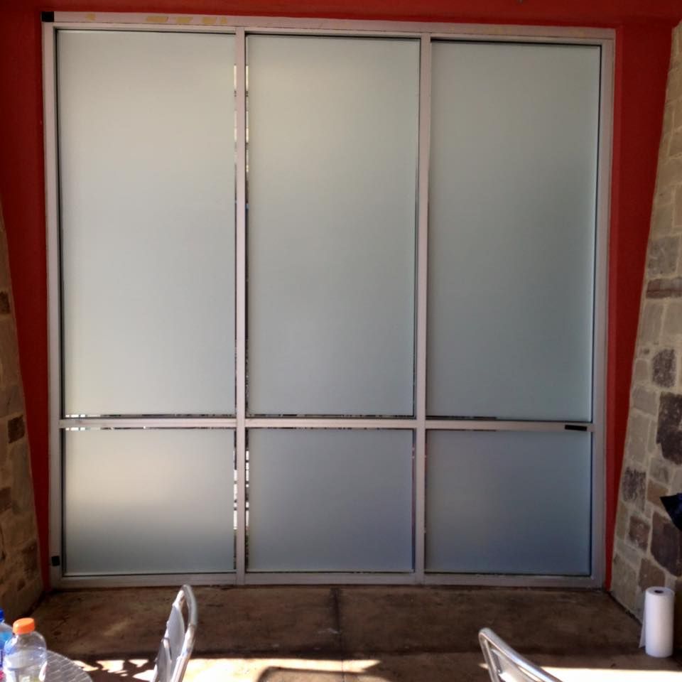 A sliding glass door with a red wall behind it