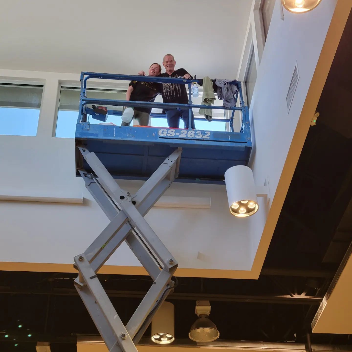 Two men standing on a scissor lift with gs-2812 written on it