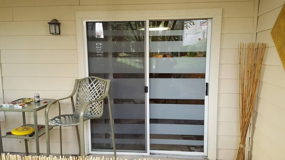 A sliding glass door with a chair and table in front of it