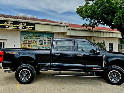 A black pickup truck is parked in front of a building.