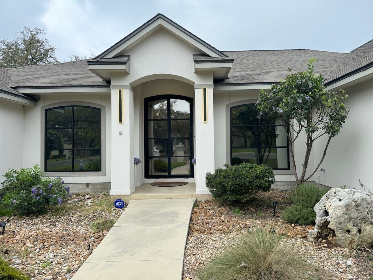 A white house with a walkway leading to the front door