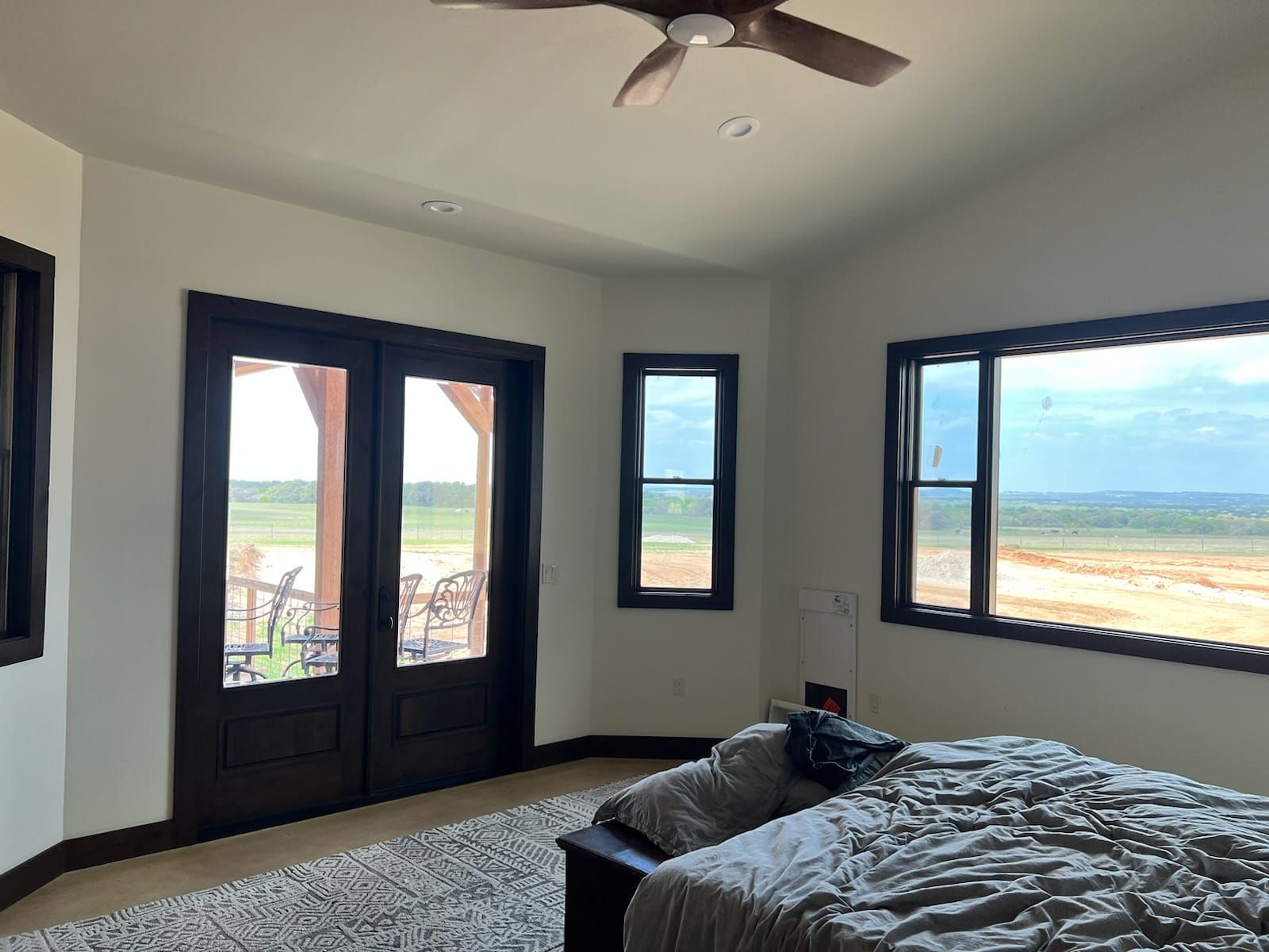A bedroom with a bed and a ceiling fan
