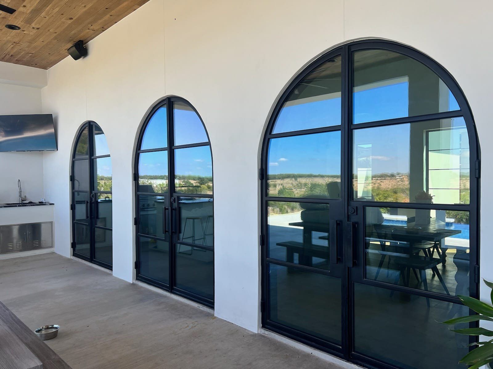 A patio with arched windows and sliding glass doors.