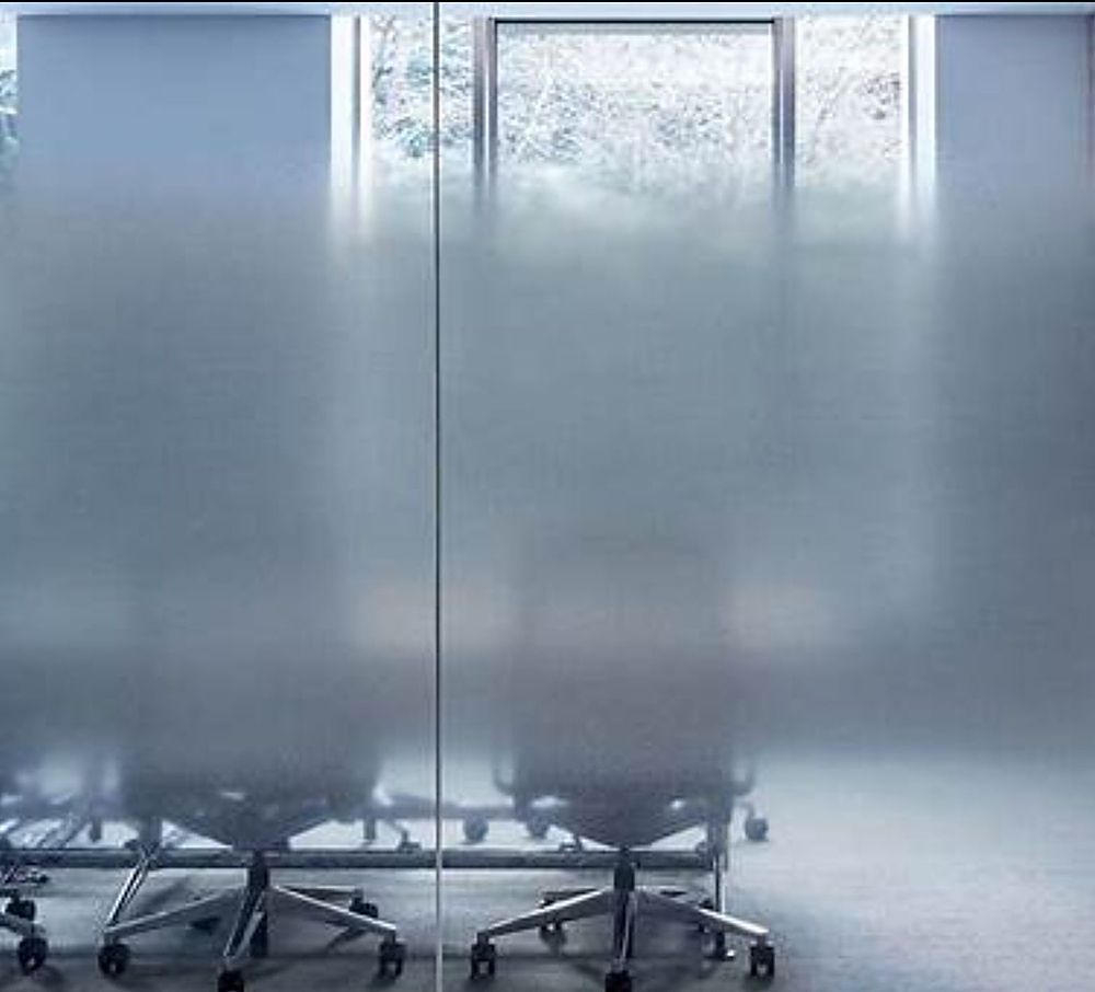 A conference room with a table and chairs in front of a glass wall.