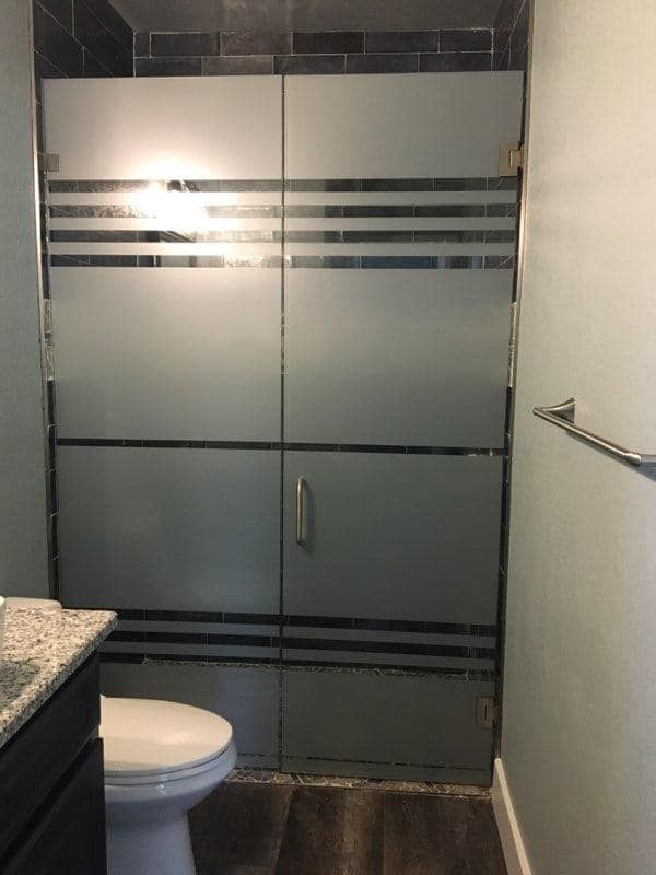 A bathroom with a toilet and a glass shower door
