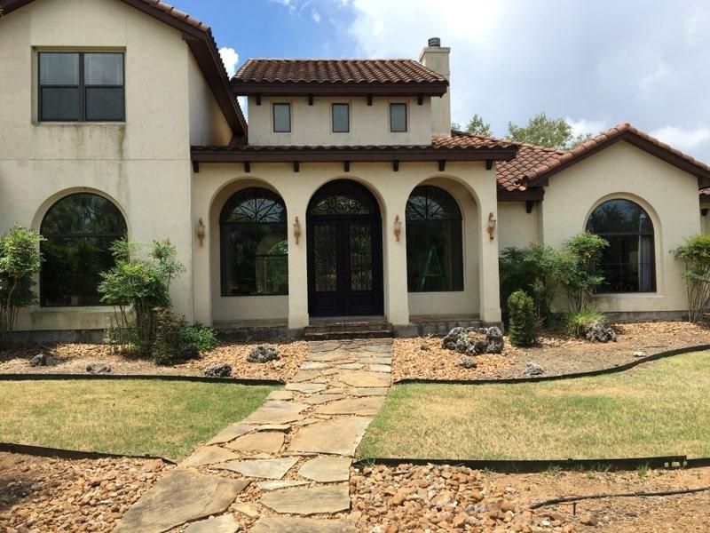 A large white house with arched windows and a stone walkway leading to it