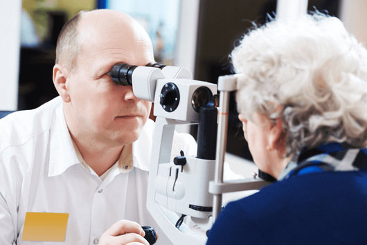 older woman getting an eye exam from doctor