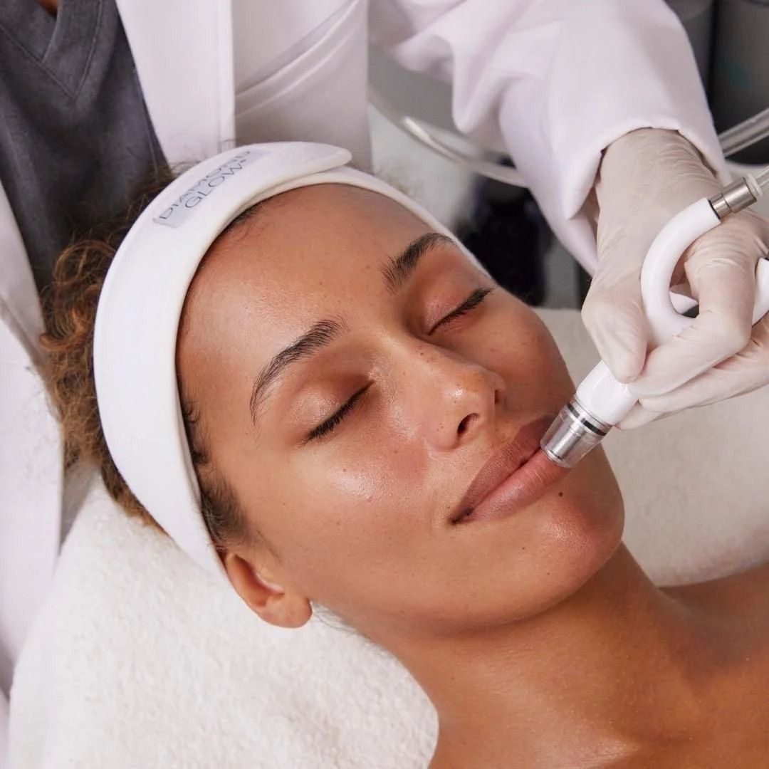 Woman receiving facial treatment; technician using handheld device near mouth.