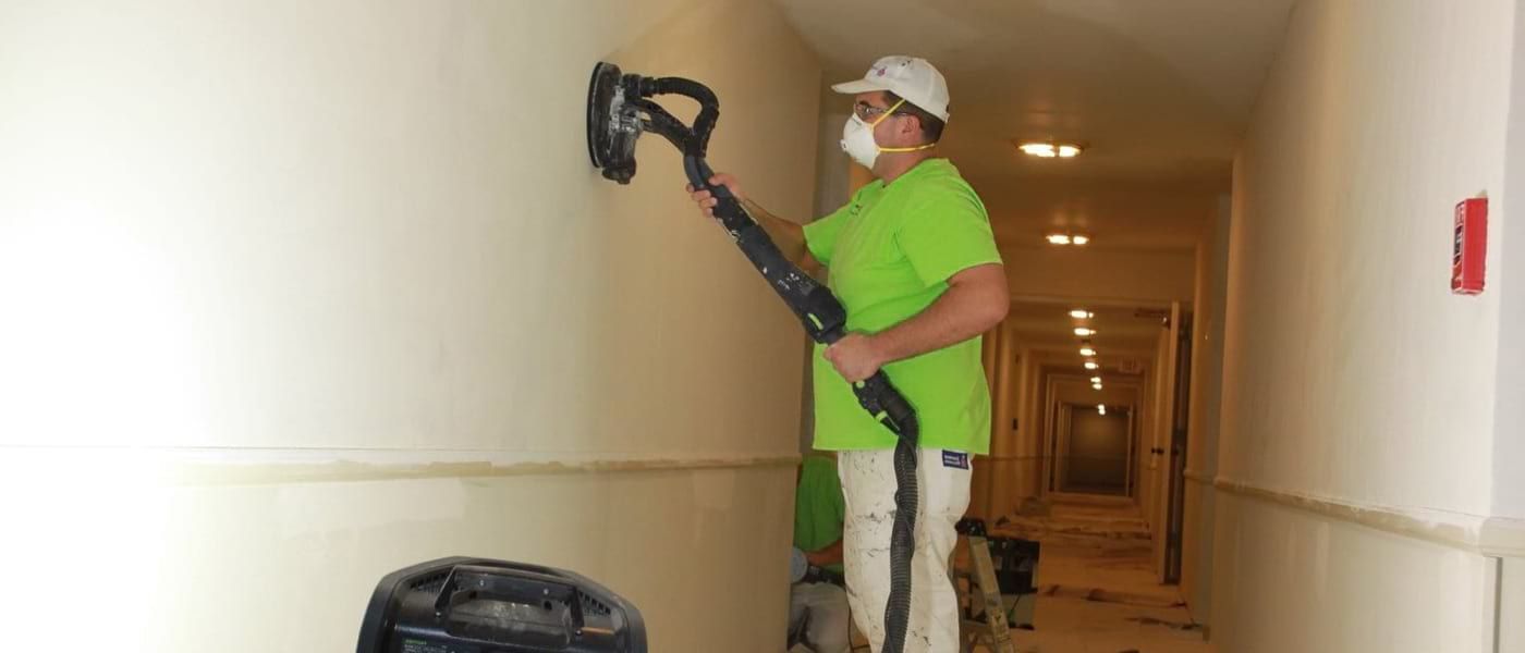 Man using a giraffe drywall sander