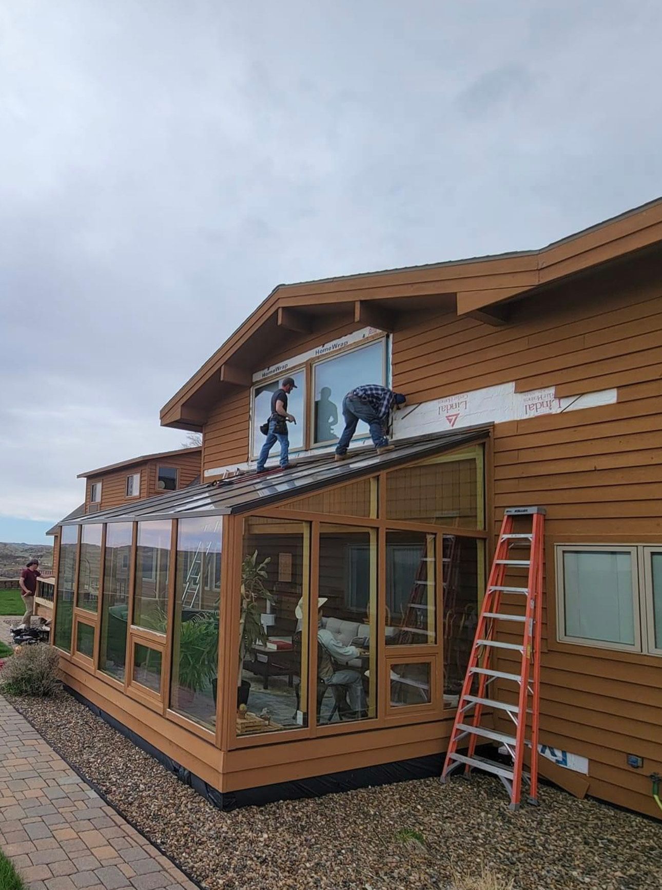 A couple of men are working on the roof of a house.