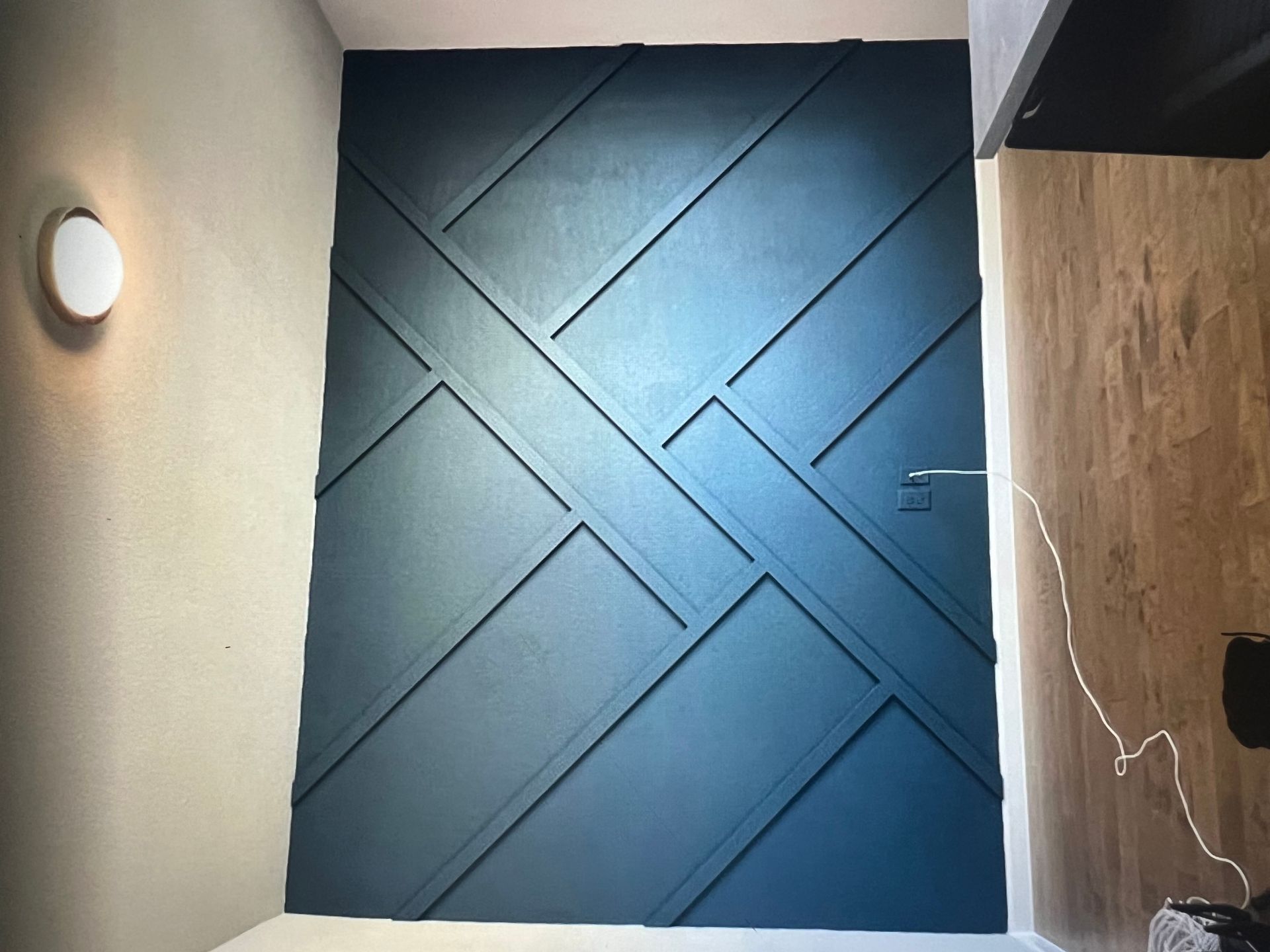 A room with a blue wall and a light on the wall