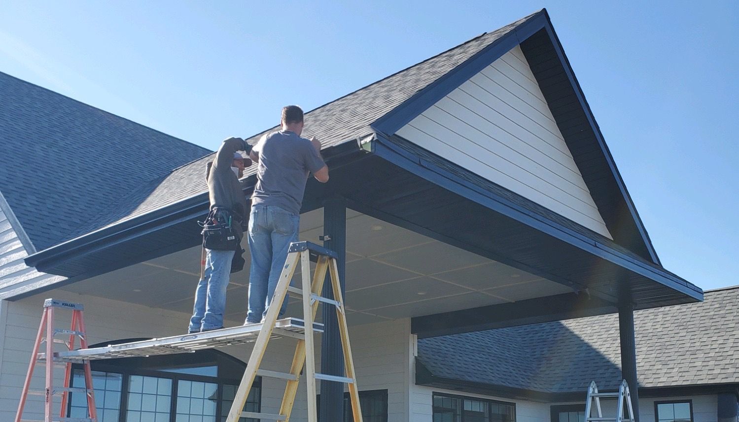 Two men are working on the roof of a building