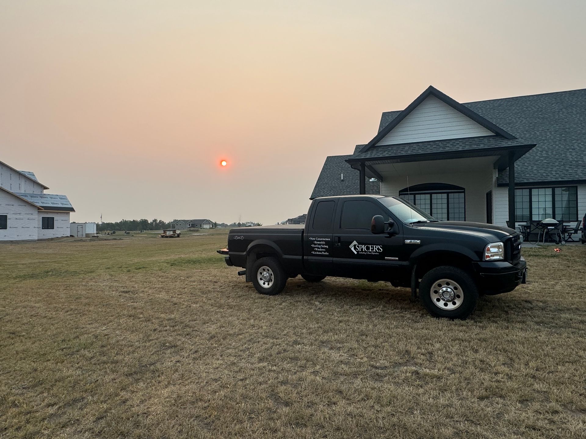 A black truck is parked in front of a house