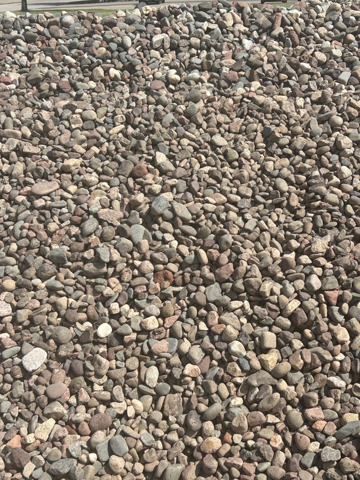 Pile of small, rounded stones in various shades of brown and gray.