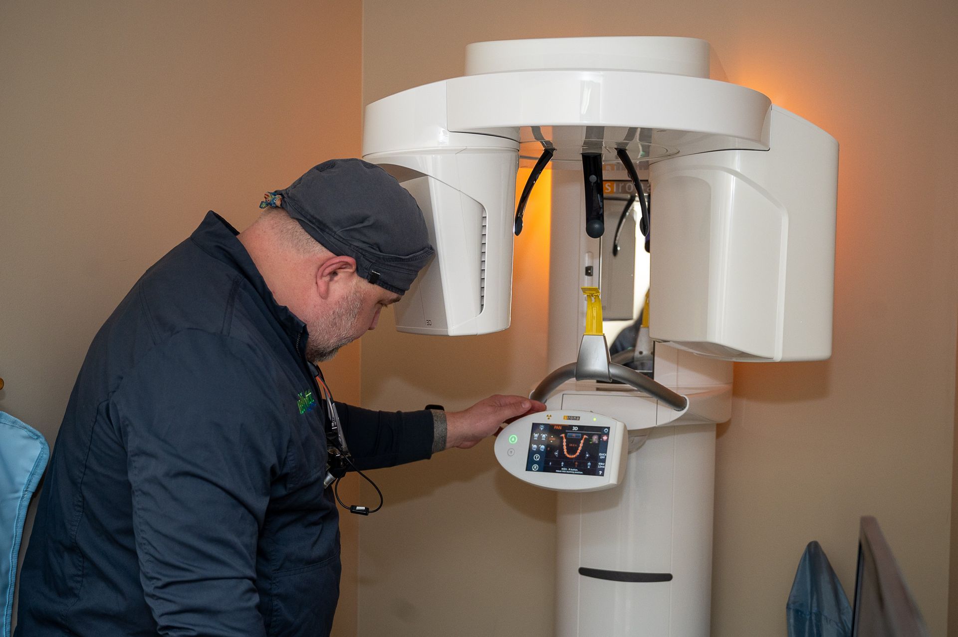 A man is looking at a machine in a dental office