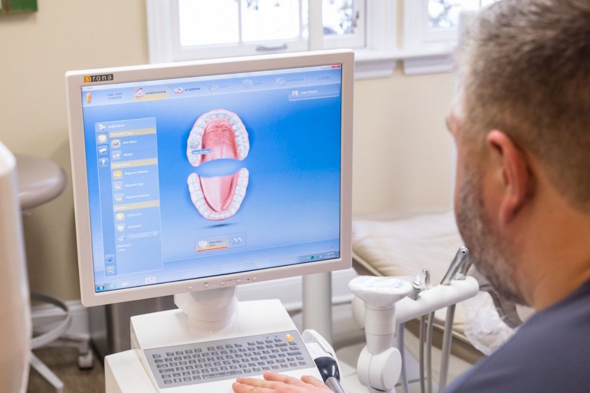 A man is looking at a computer screen in a dental office