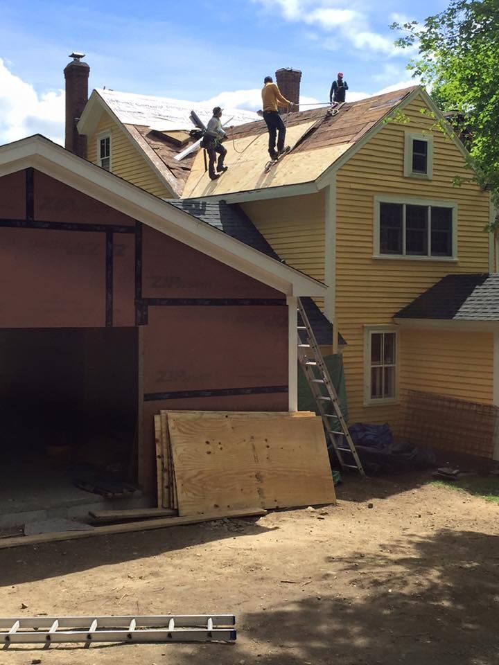 Two men are working on the roof of a house.