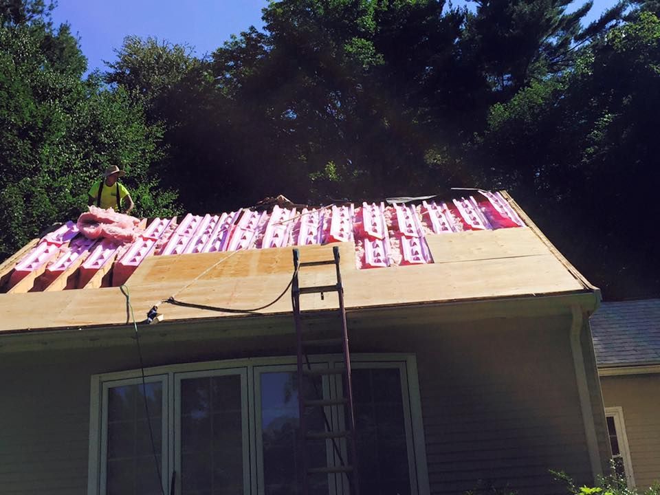 A man is working on the roof of a house