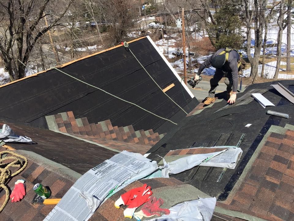 A man is working on the roof of a house.