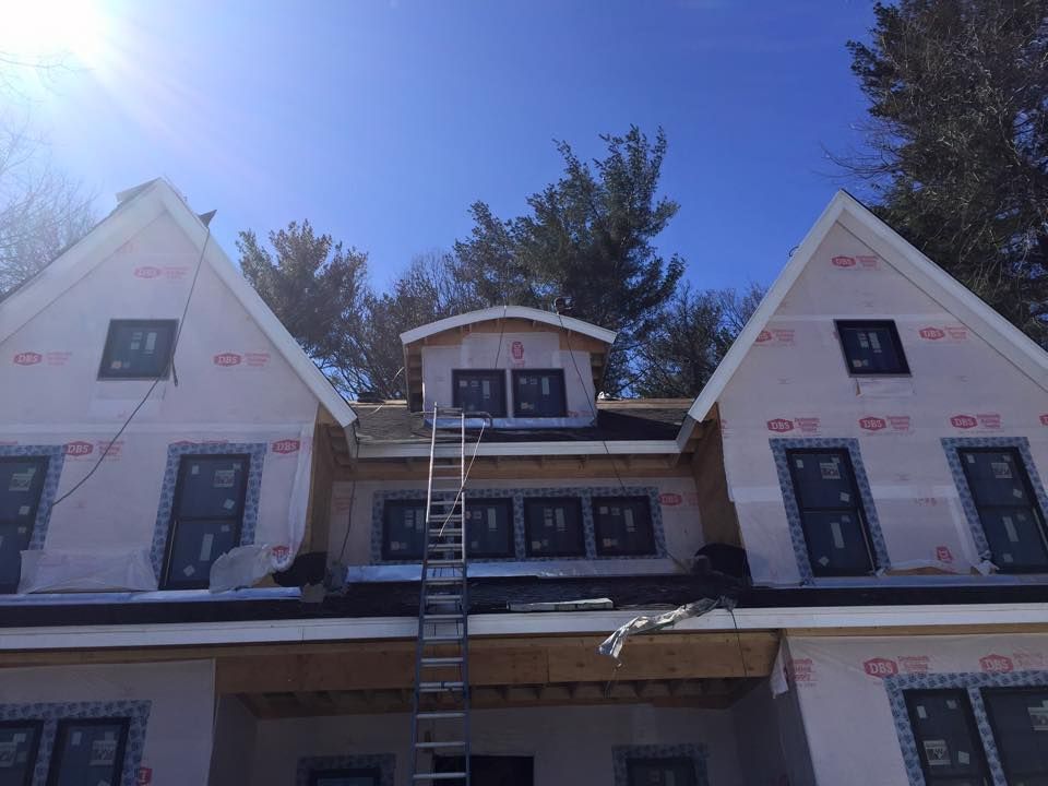A house under construction with a ladder on the roof