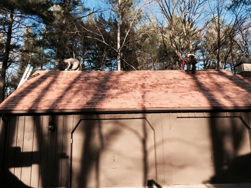 A man is working on the roof of a garage.