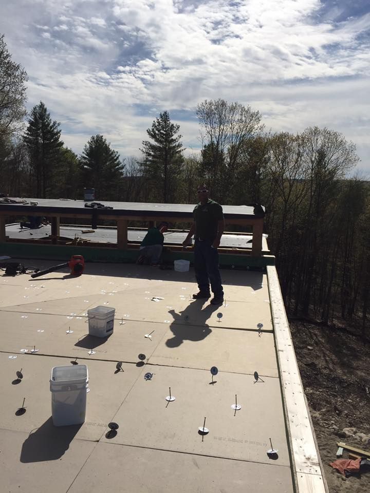 A man is standing on the roof of a building.