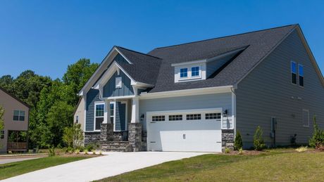 A house with a gray roof and a white garage door