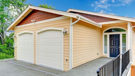 A house with two garage doors and a black door.