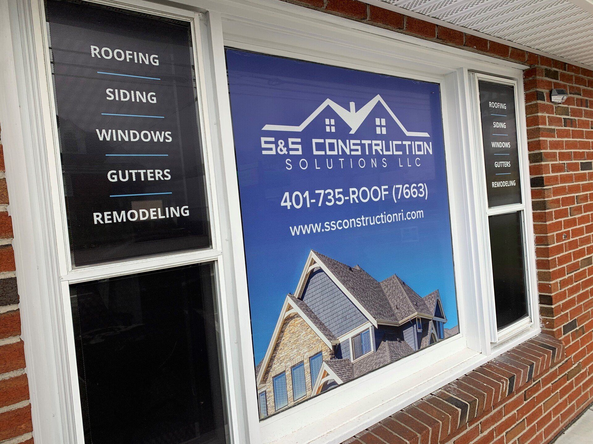 Window with S&S Construction Solutions LLC logo and services listed: roofing, siding, windows, gutters, and remodeling, with contact info.