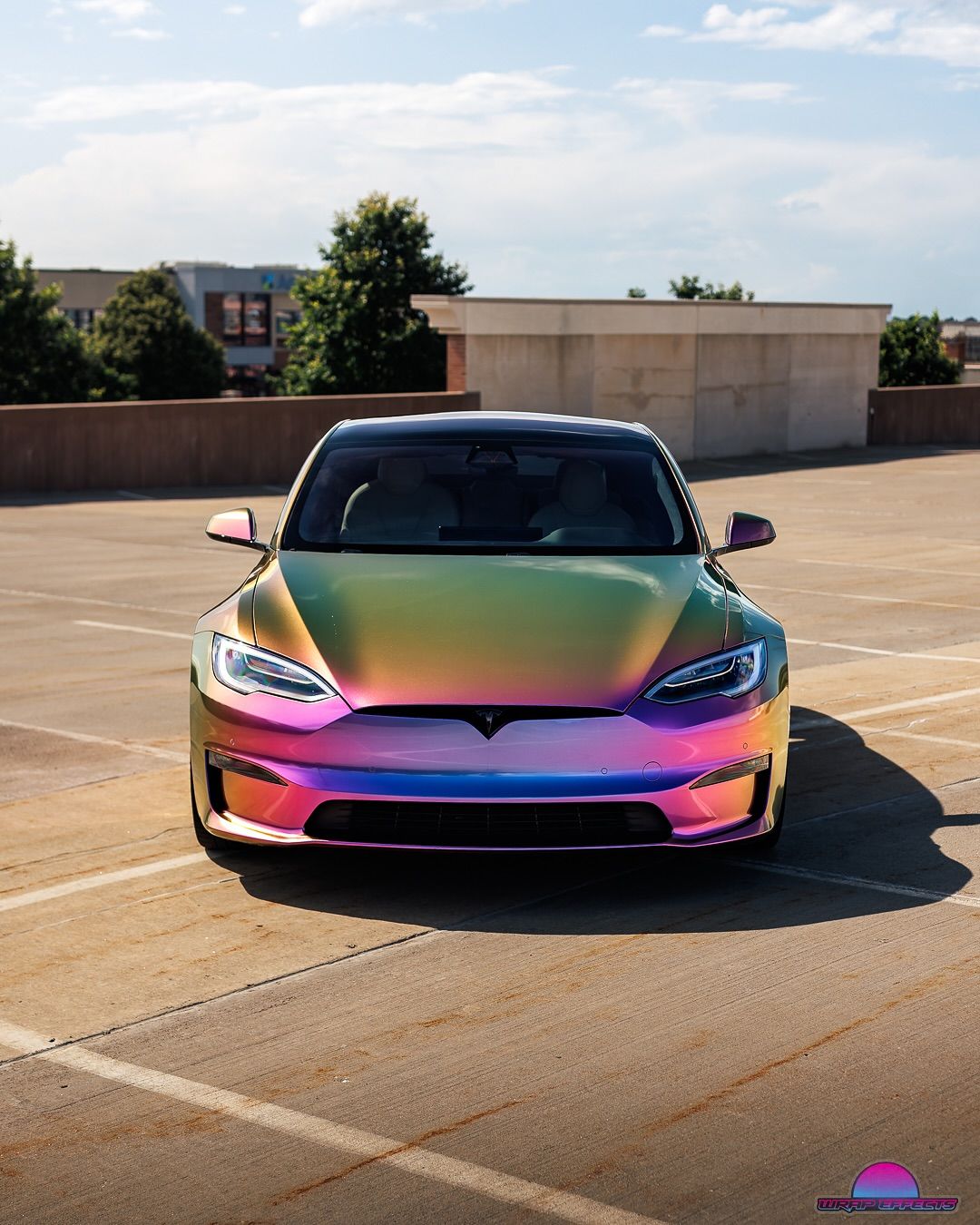 Tesla Model S with iridescent wrap parked on a rooftop.