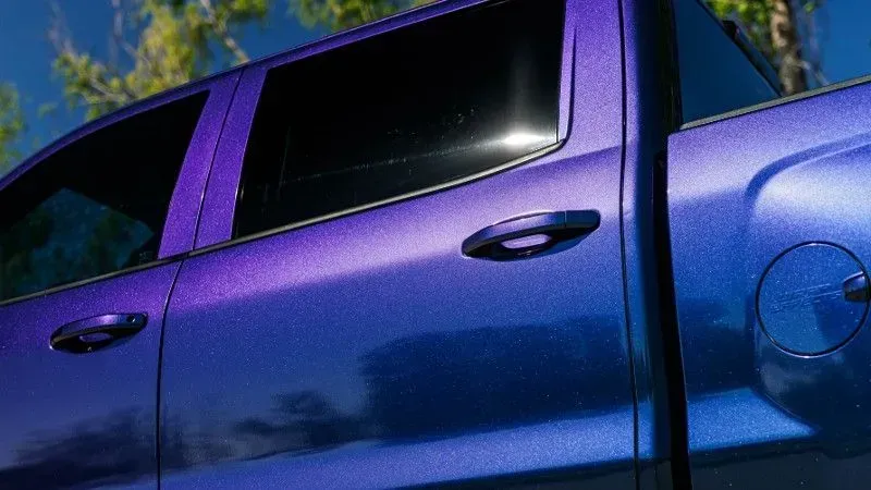 Purple-blue gradient pickup truck side, door handle, and fuel door visible.