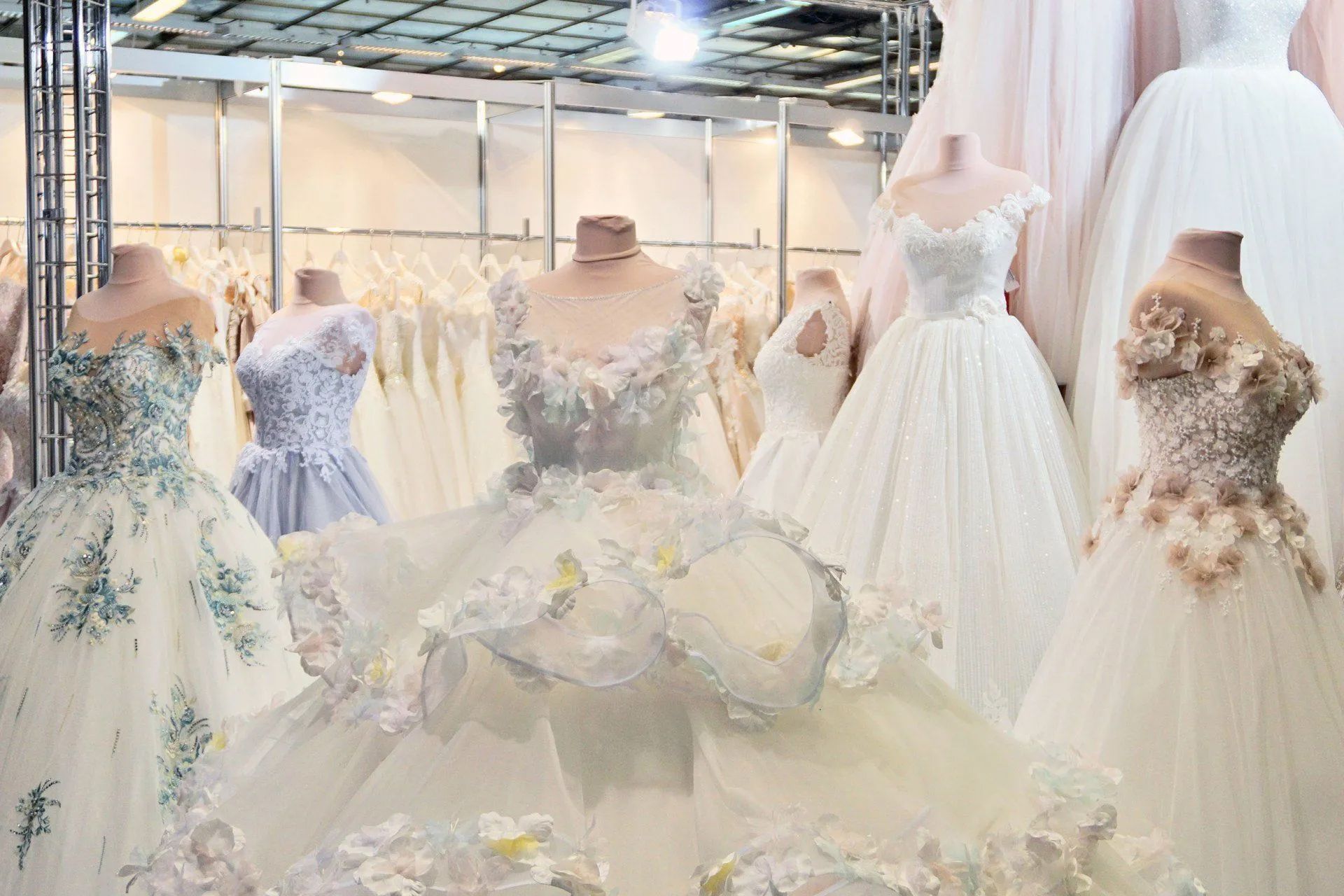 Wedding dresses on display in a store, featuring various styles and details like lace and embellishments.