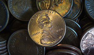 Penny on a handful of coins