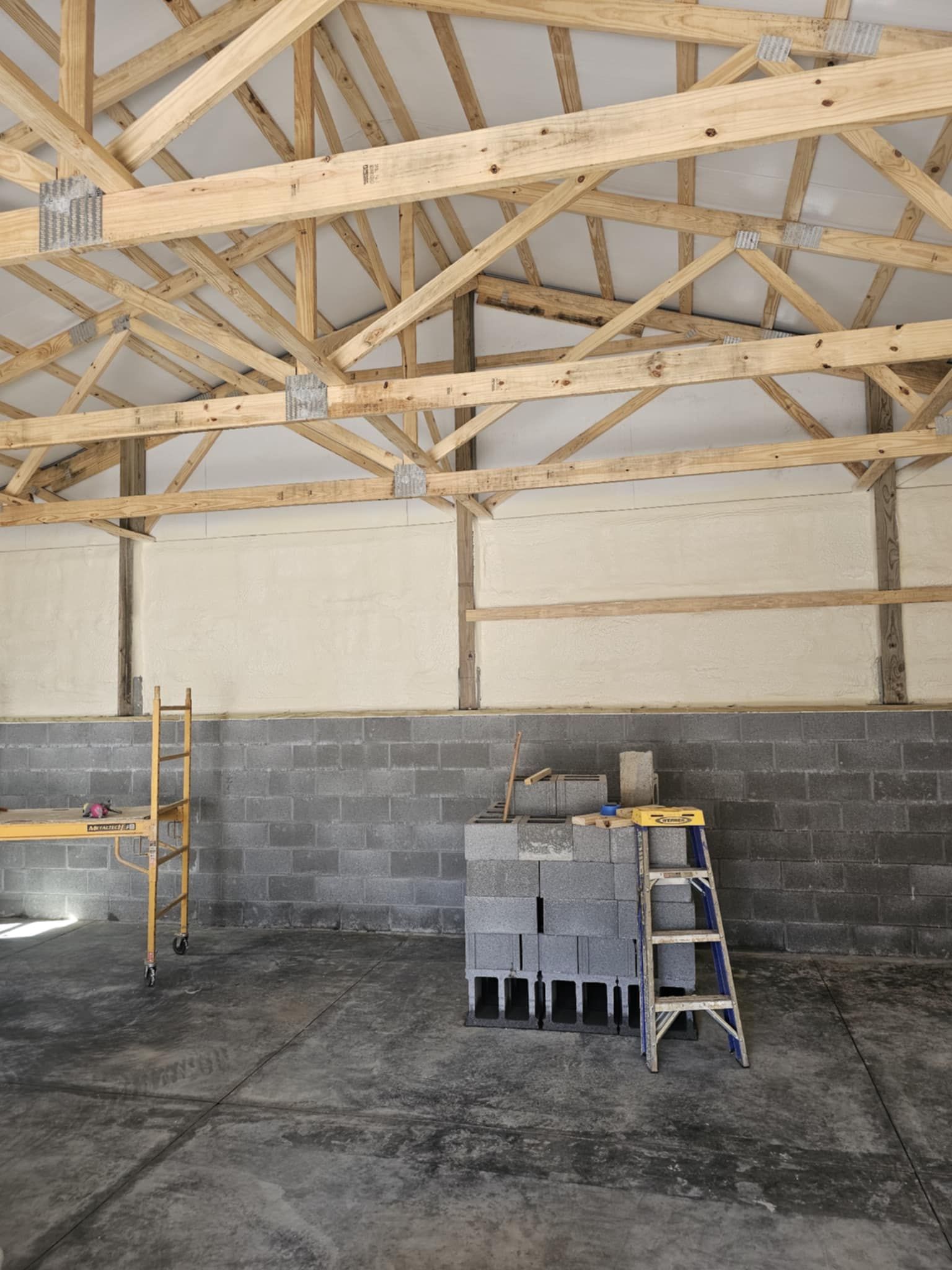 A building under construction with wooden beams and brick walls