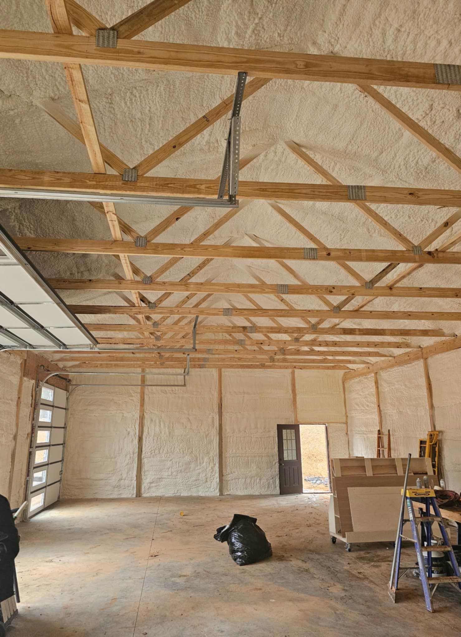 A large empty room with wooden beams and foam on the ceiling.