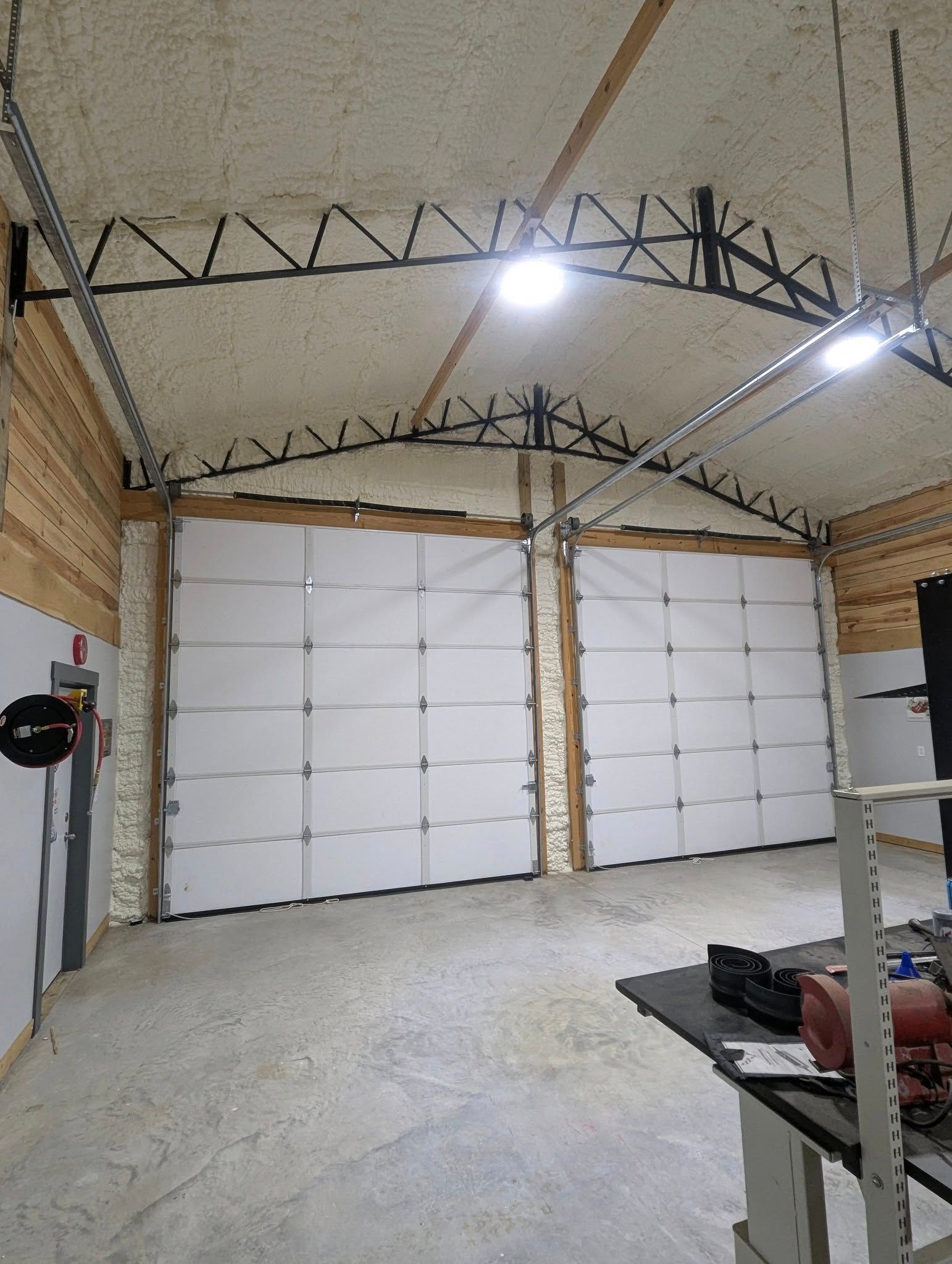 A large garage with a lot of garage doors and a ceiling.