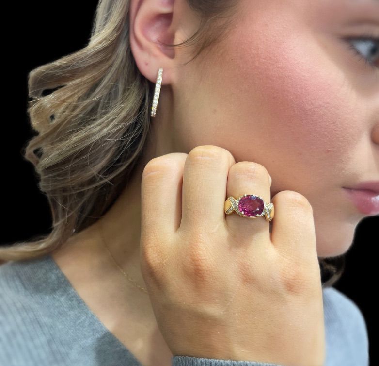 A woman is wearing a ring and earrings on her left hand