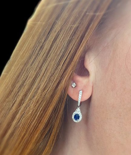 A close up of a woman's ear with a pair of earrings.