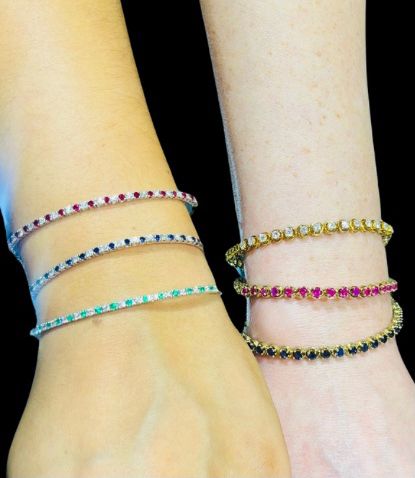 A woman is wearing three different bracelets on her wrist