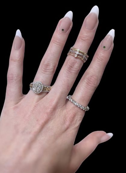 A woman's hand with three rings on her fingers