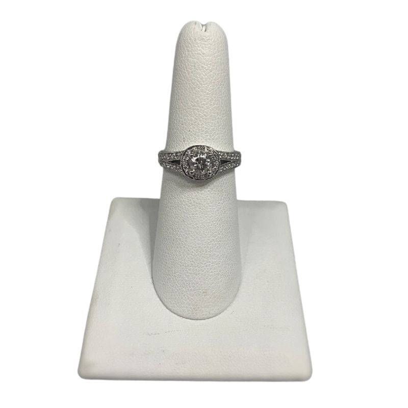 A diamond ring is sitting on a white ring holder.