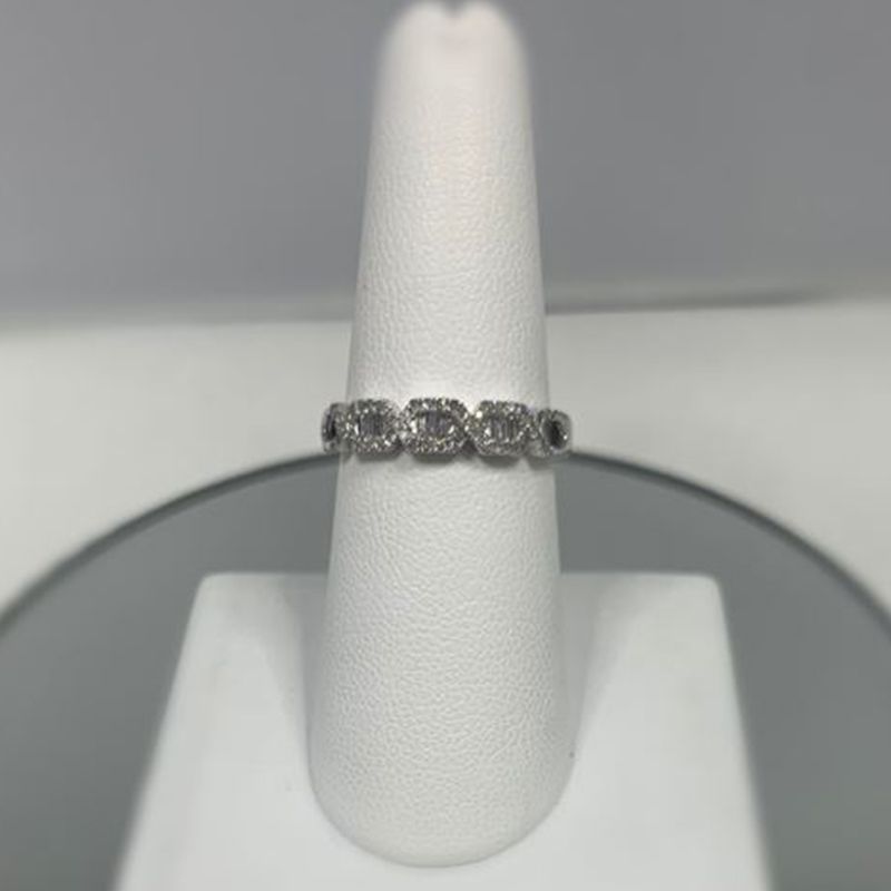 A silver ring is sitting on a white ring holder