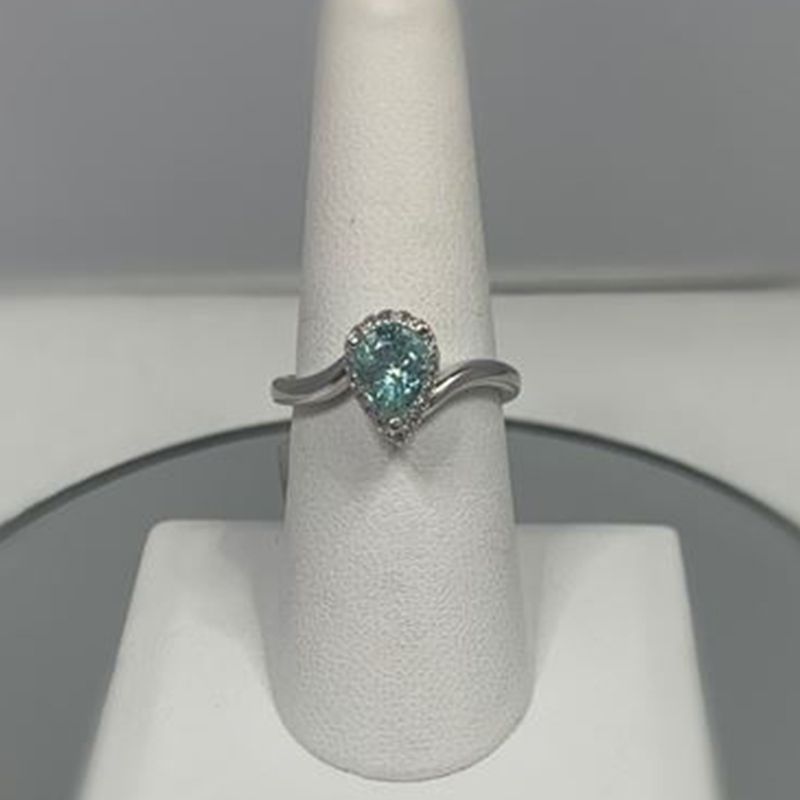 A ring is sitting on top of a white ring holder.