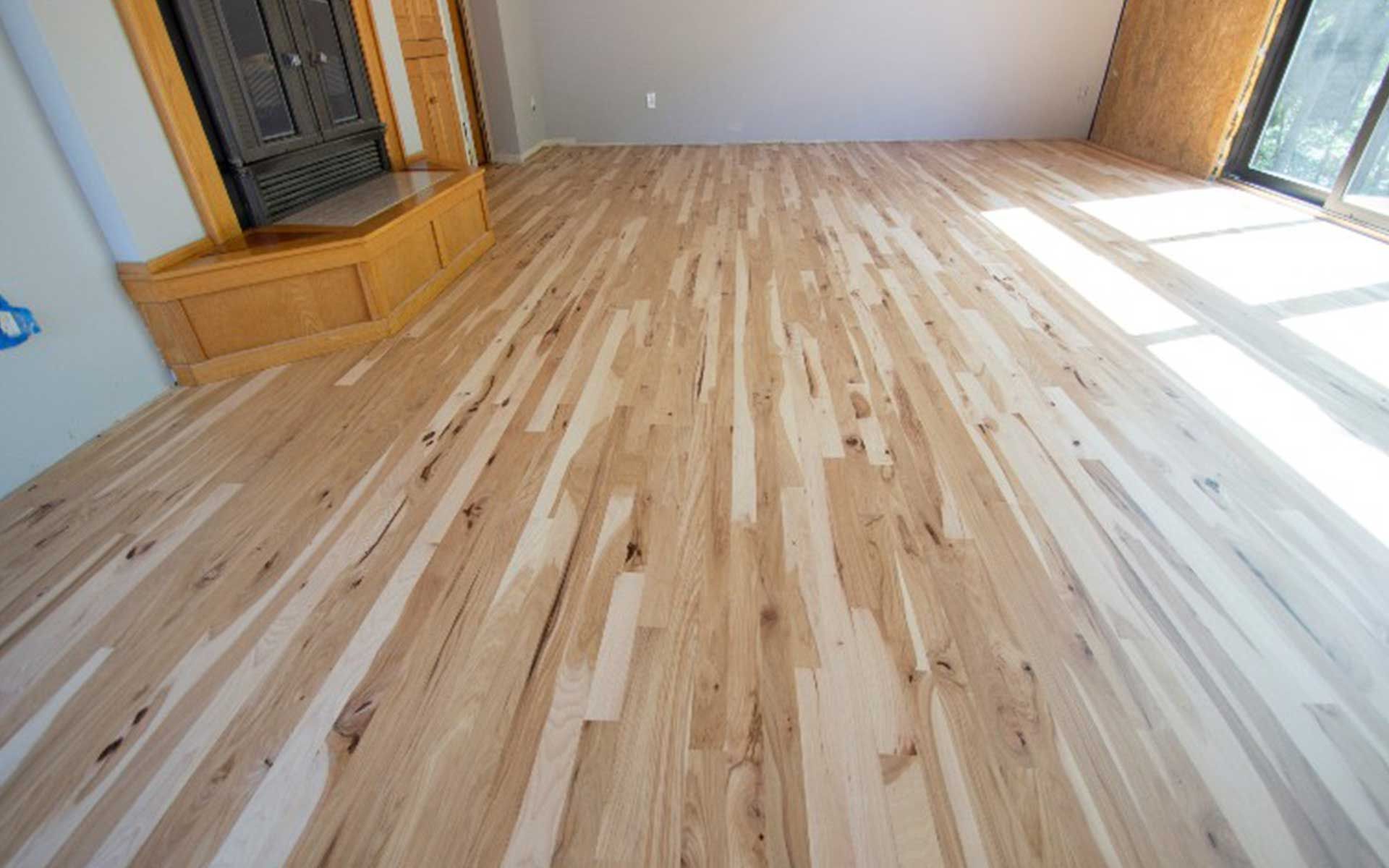 A living room with a wooden floor and a fireplace.