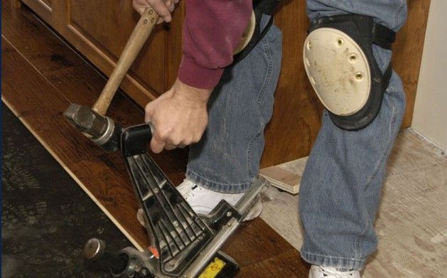 A person is using a machine to cut a piece of wood.