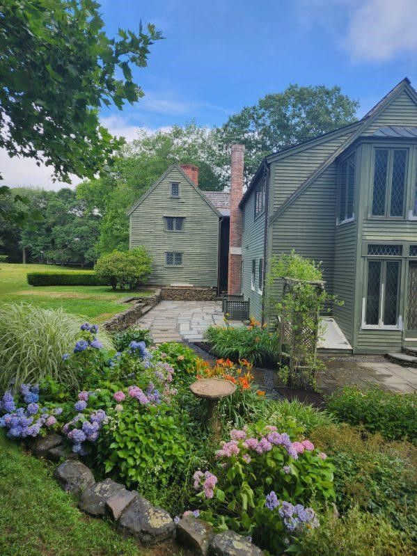 A house with a garden in front of it on a sunny day.