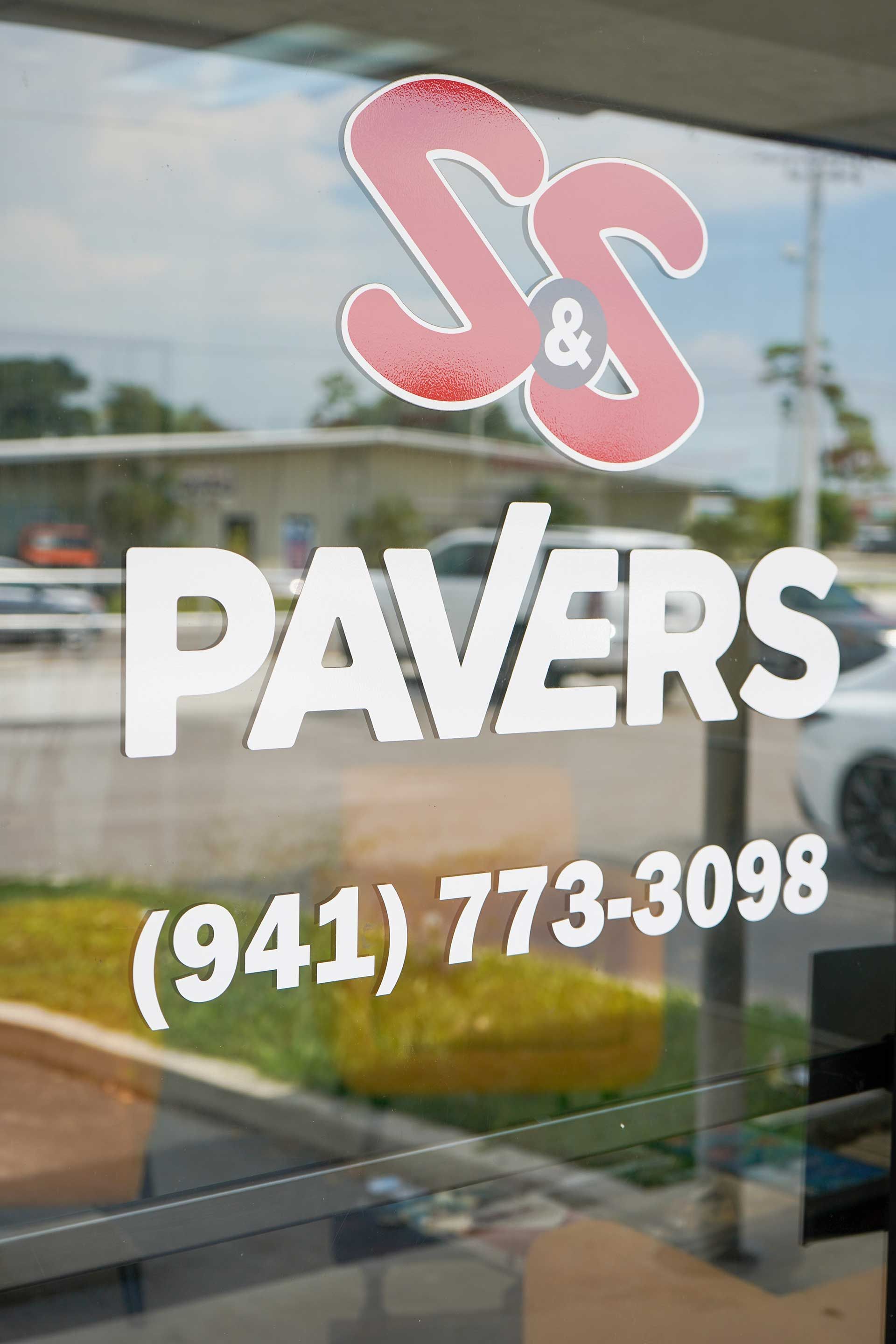 a sign for S & S Pavers is on a window