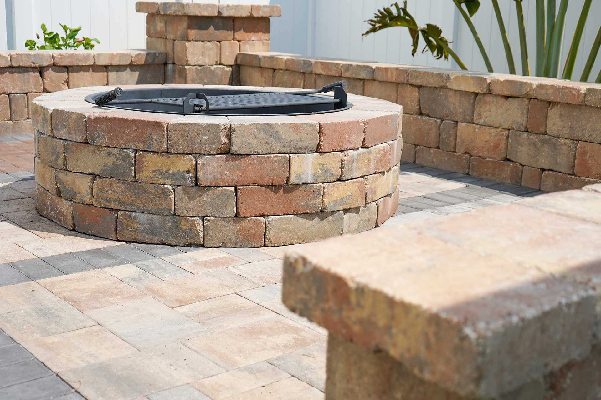 a firepit made of bricks on a patio next to a bench