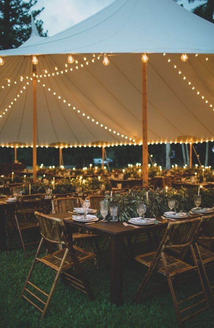Outdoor wedding reception venue with tables set for guests under a tent