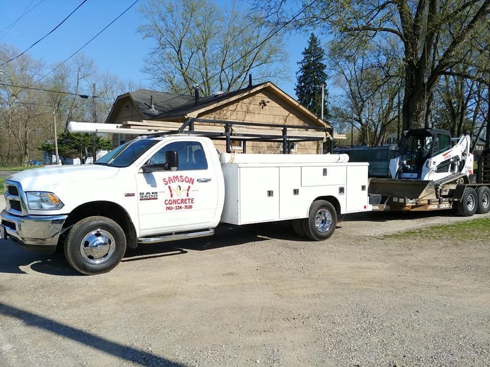 A white utility truck is parked in front of a house